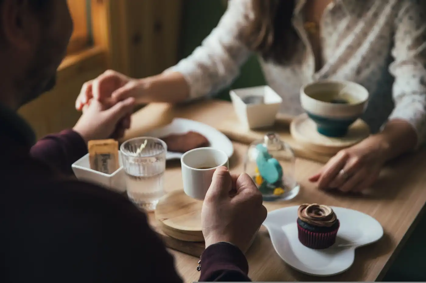 Two people enjoying coffee and brunch pastries at a sunlit table in Carl's Coffee